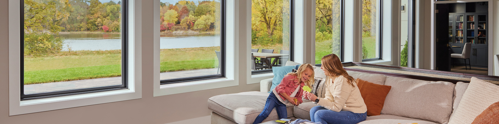 Young girl and mom in basement with large windows