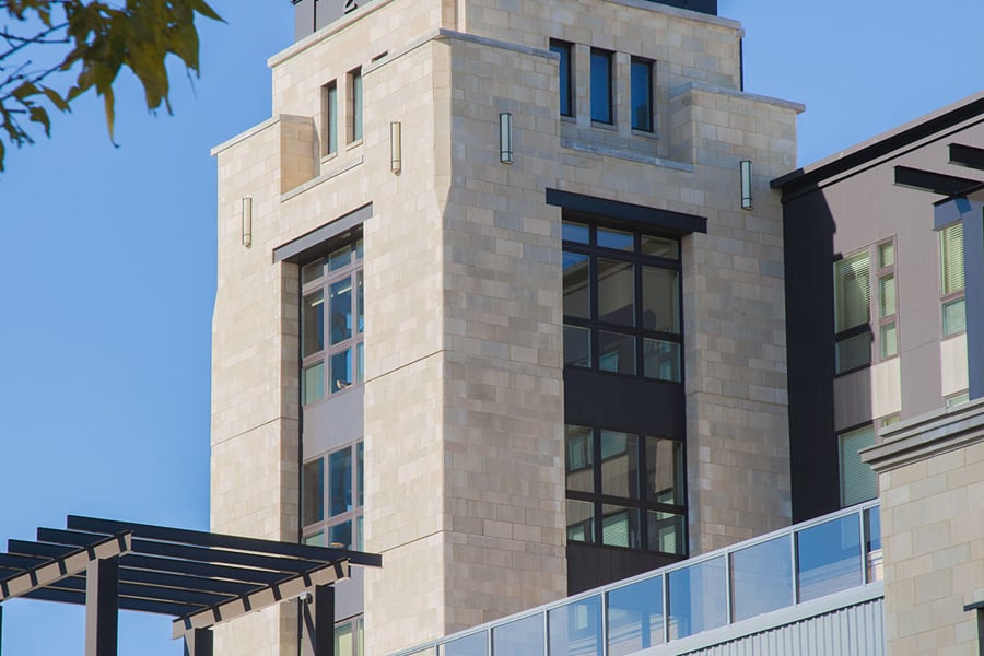 Stone building with tall tower with dark paneled windows