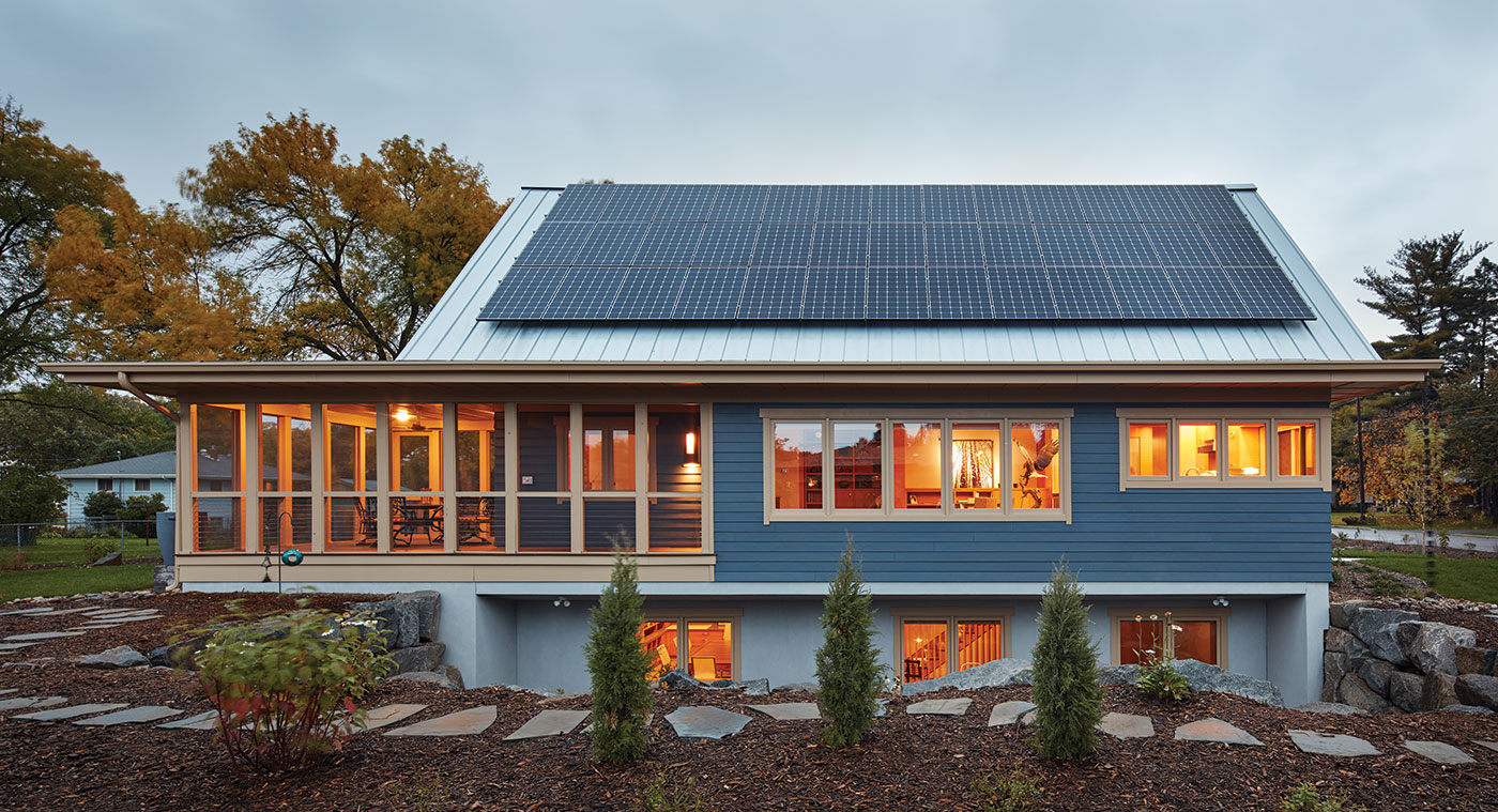 A single-story home with a metal roof featuring a solar array and generous screened-in porch.