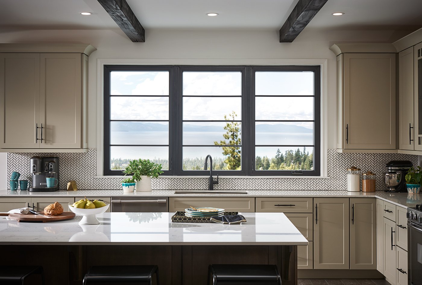 Black casement windows with specified equal light grilles over a kitchen sink with a view of a lake and forest.
