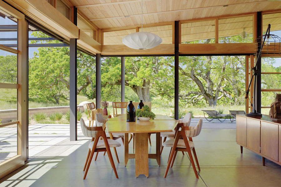 patio area with wood table and chairs under wood cover