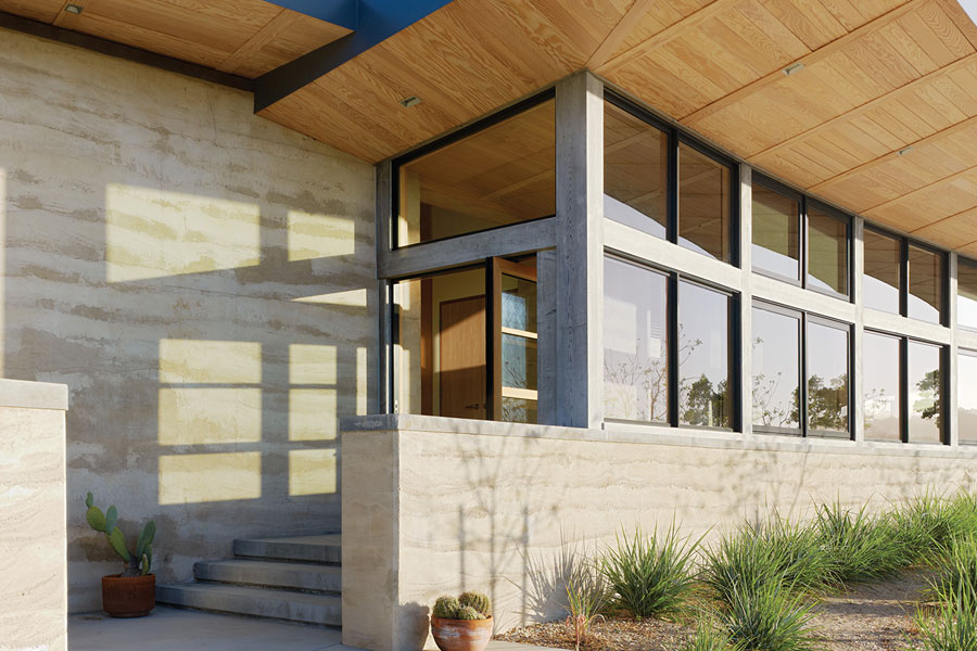 Two views of the home’s entrance, which features a Pivot Door with a clerestory window above.