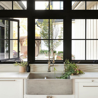 A double row of black casement windows above a kitchen sink.