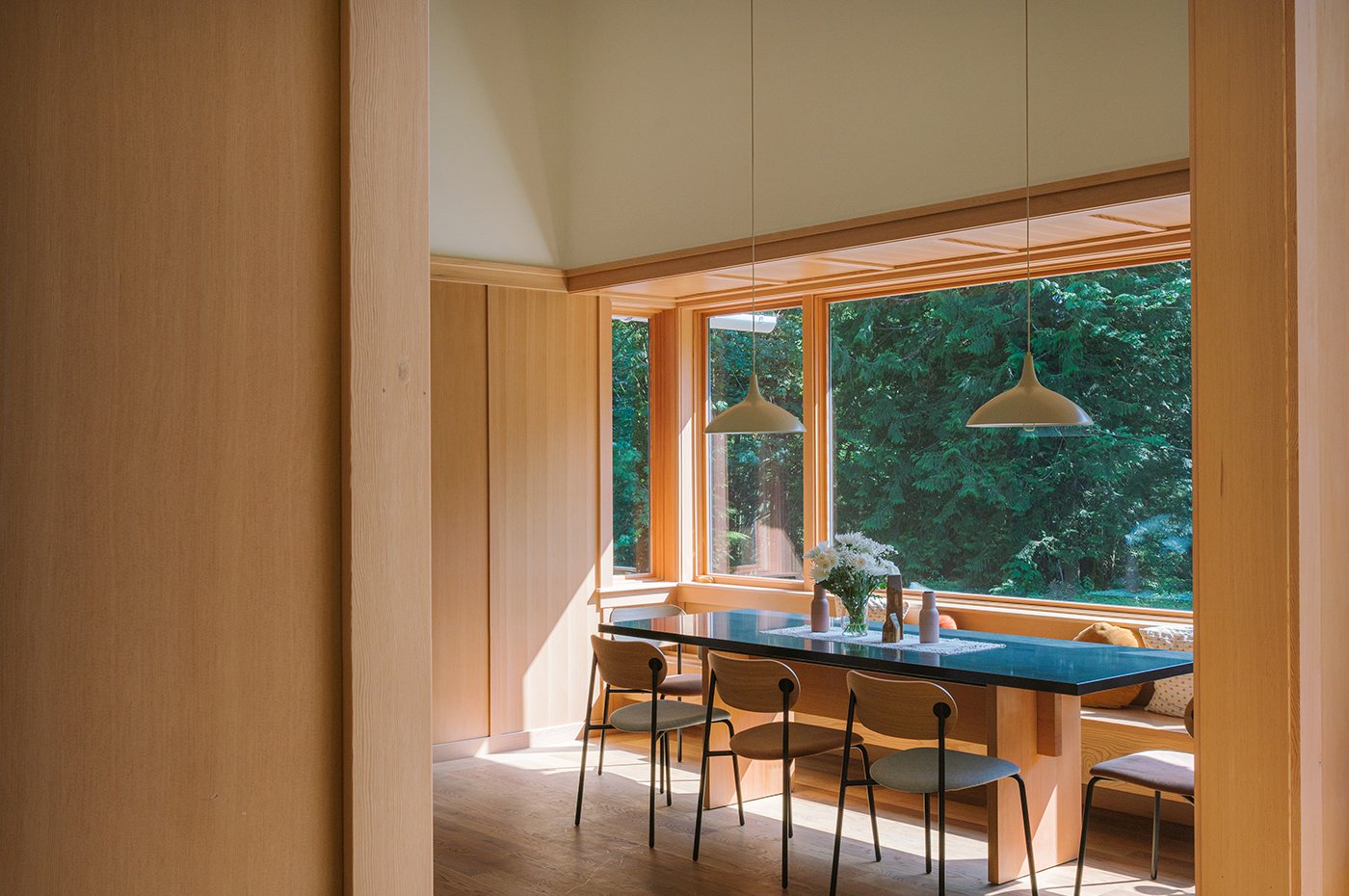 A breakfast nook that’s set inside a massive bay window composed of Andersen® E-Series windows.