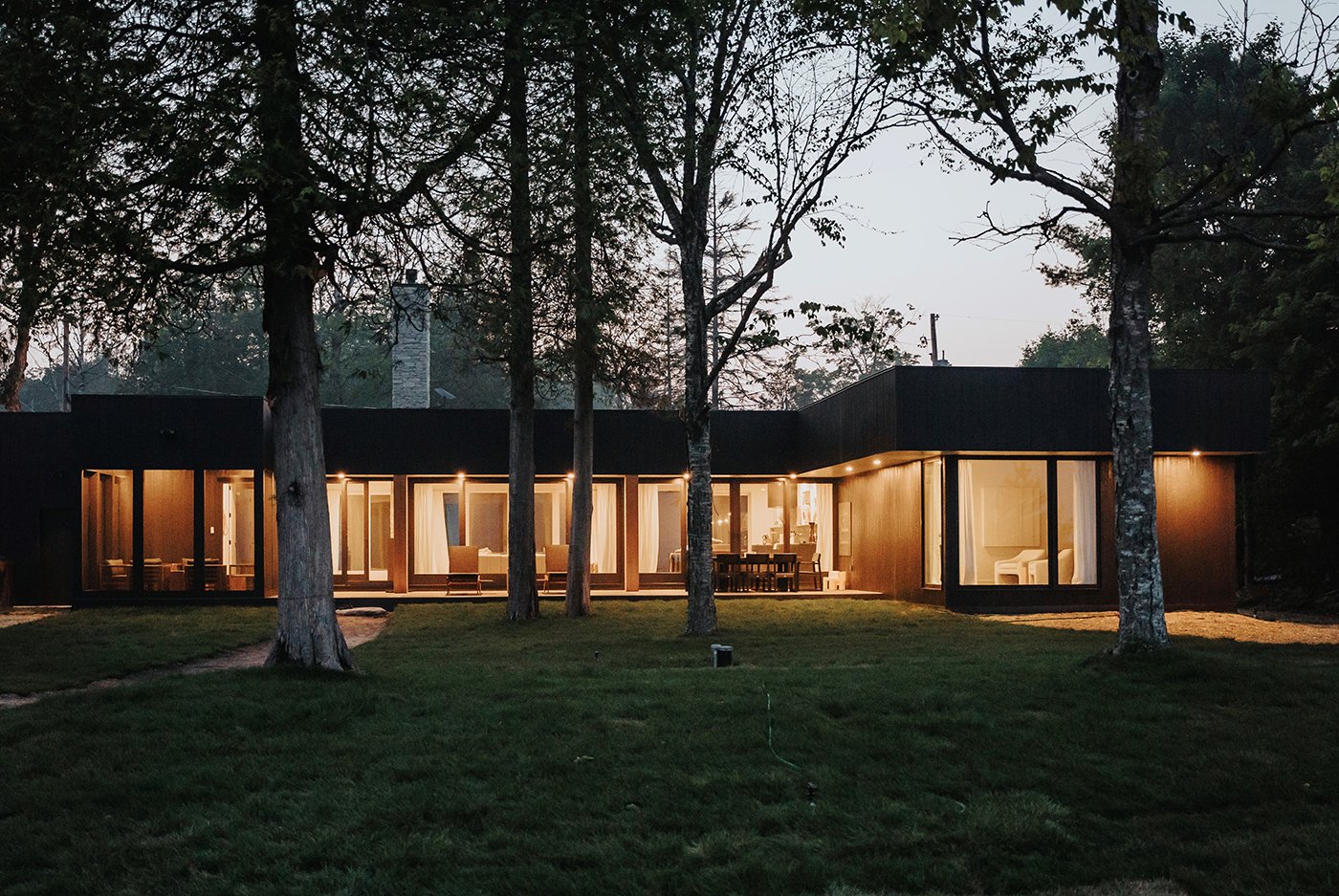 A modern home with floor-to-ceiling windows and gliding patio doors.