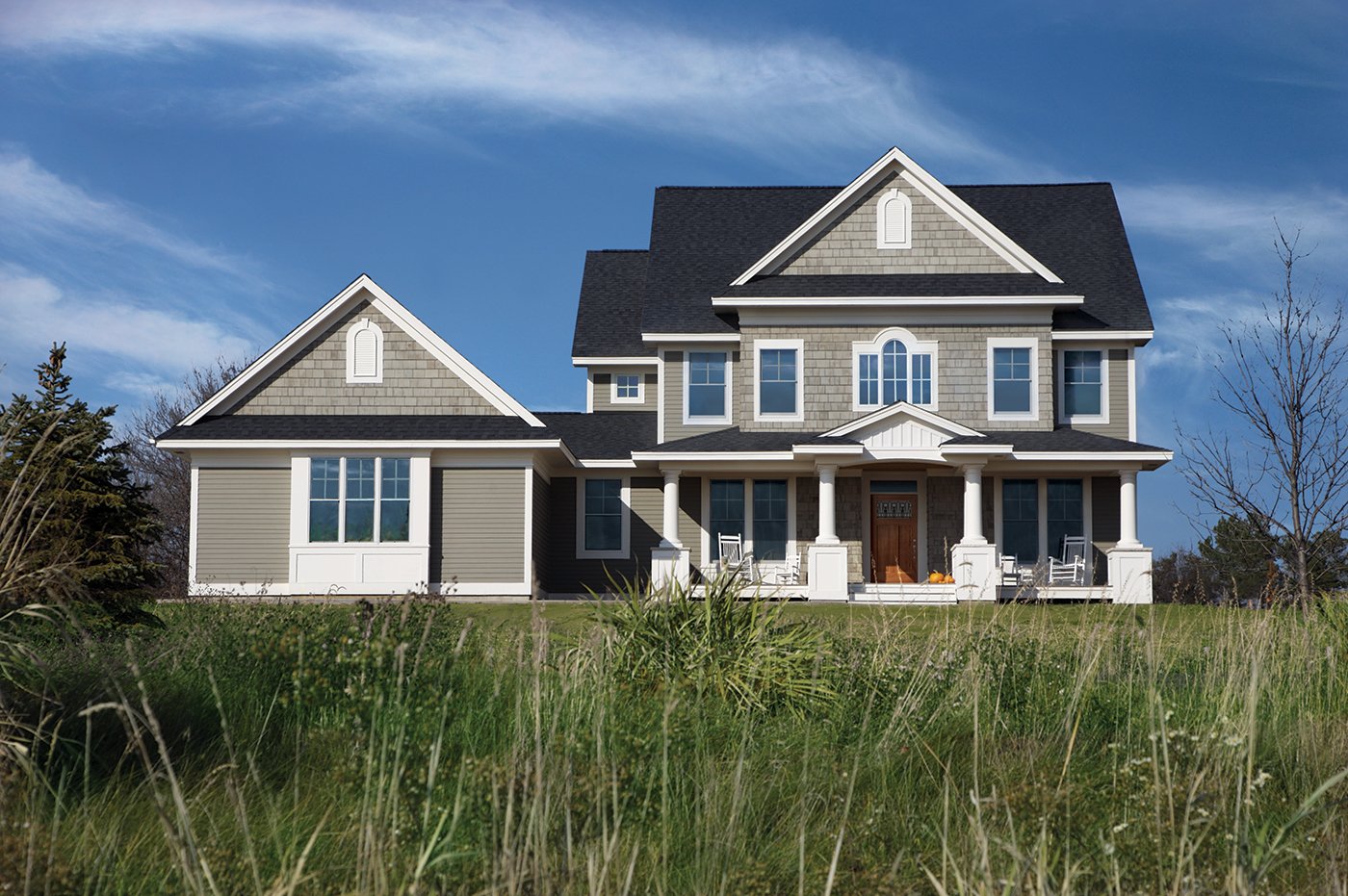 A new construction home with a classic look, including a window combination on the upper floor with a Springline window in the center.