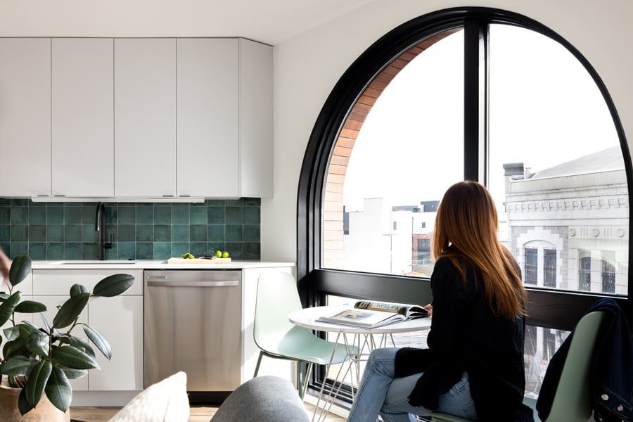 An apartment with a large arch-shaped window that takes up a full wall.