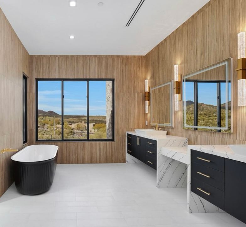 Interior bathroom rendering of a contemporary luxury home in the desert with a wall of large, black Andersen® 100 Series Picture Windows providing unobstructed views of the landscape beyond. 