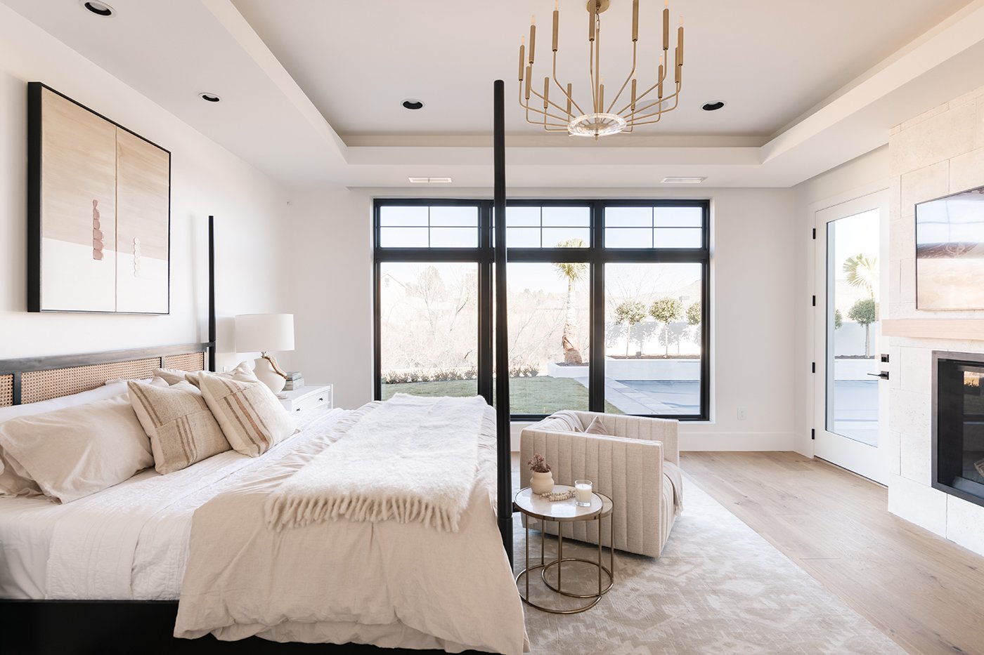 A bedroom with three large, black windows taking up almost the entire back wall.