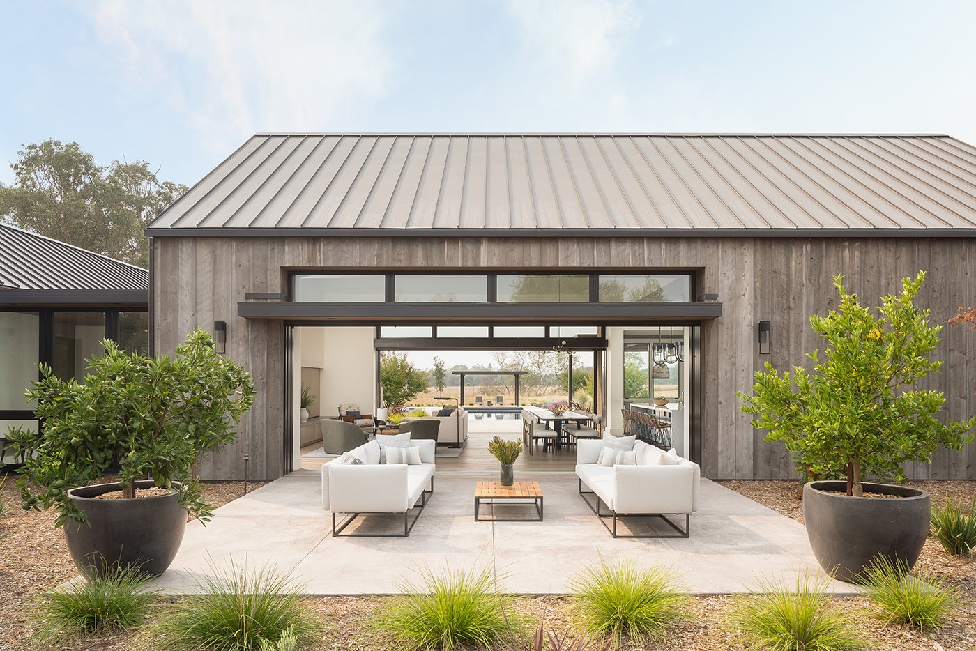 Two Andersen Liftslide Doors, this Sonoma farmhouse merges north and south patios with the living room