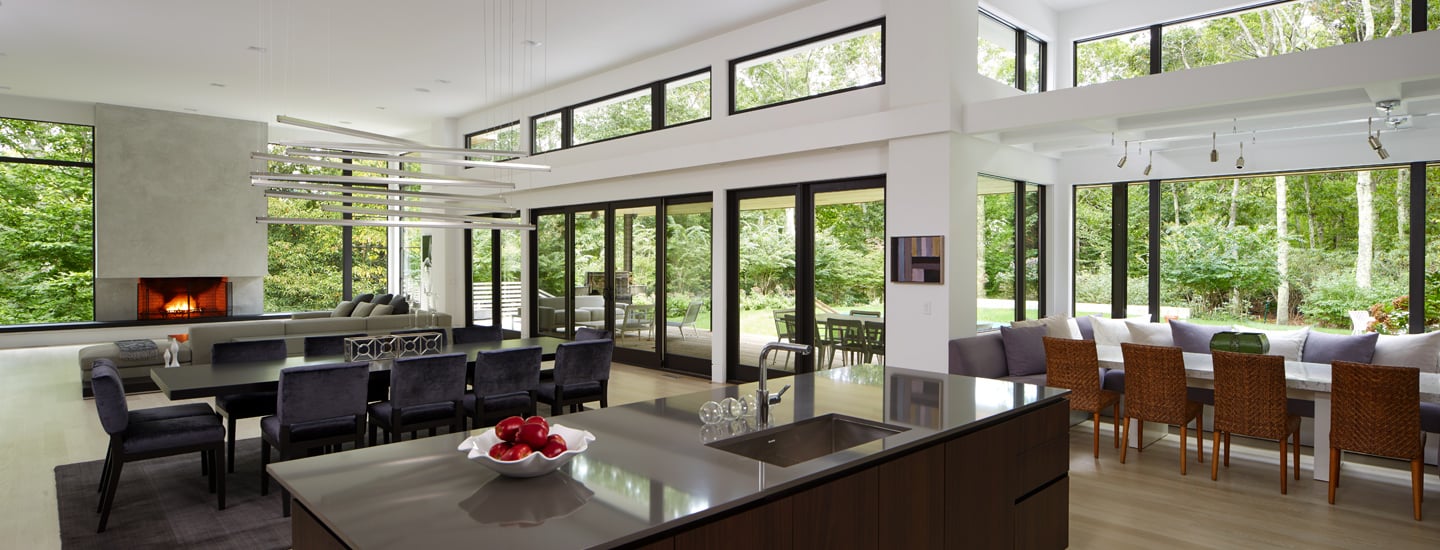 Open, minimalist concept kitchen and dining room with E-Series picture windows and gliding patio doors, including bi-parting patio doors; Black exteriors and Black painted interiors