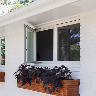 White home with wood planters box below open casement window
