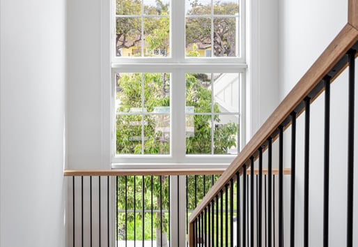 Stairway with floor to ceiling windows with vaulted ceilings