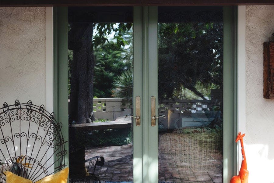 An after photo of a new E-Series Hinged Patio door, on the left, and a before picture of the same opening with the old French door, on the right.