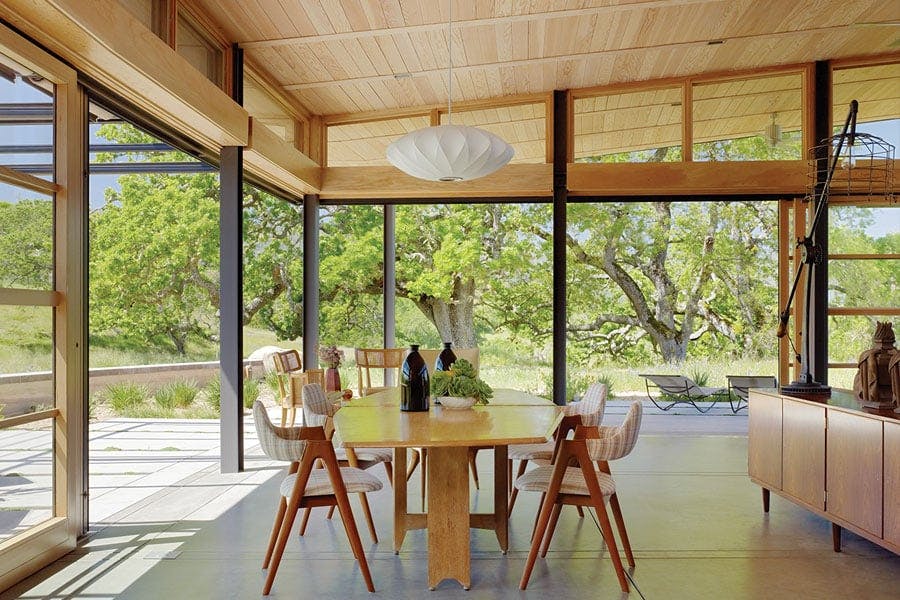 A dining room that opens completely to the outdoors through corner connected Liftslide Doors.