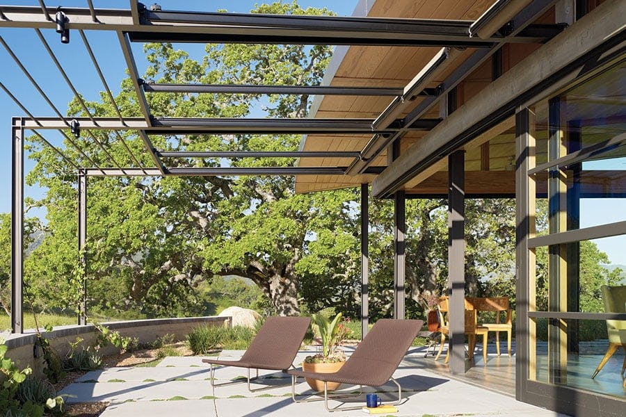 A terrace with overhead beams that accommodate retractable sunshades.