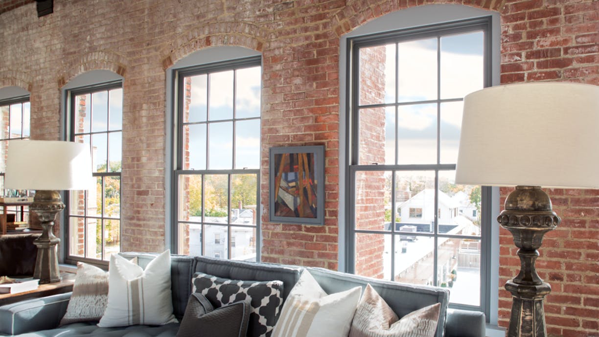 Interior of  a loft featuring Andersen E-Series Double-Hung Windows with Colonial Grilles.